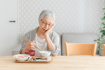 食事中に痛みを感じる女性